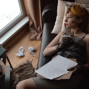 thoughtful writer with paper resting on sofa at home