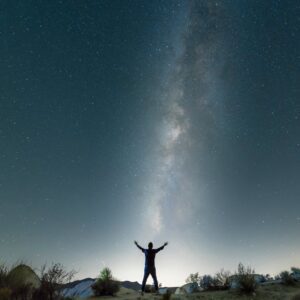 a man standing under a starry night sky