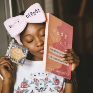 girl wearing white and red floral shirt with bow headband closing her eyes while holding body blendz book