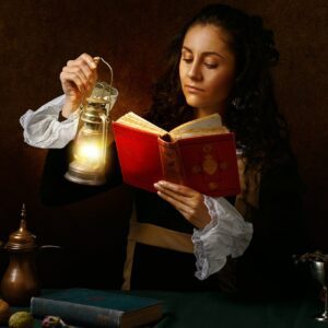 focused woman in old outfit reading book with oil lamp
