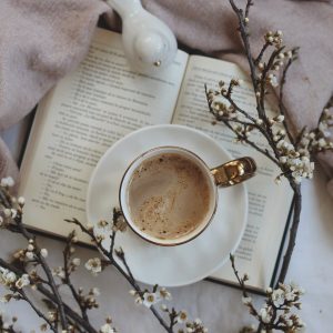 a cup of coffee on top of an open book
