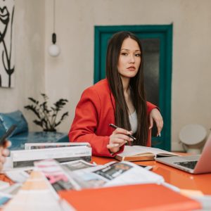 a woman in red blazer working in the office
