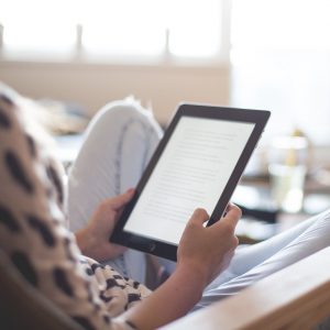 woman sitting on chair using black ipad