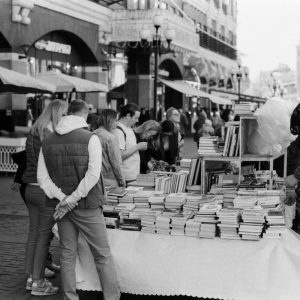 people on the street market looking at books