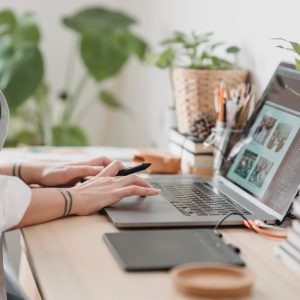 woman working retouching photo on laptop at convenient workplace