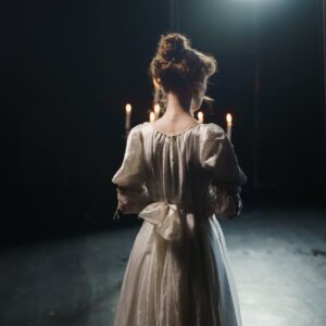 back view of a woman holding a candelabrum