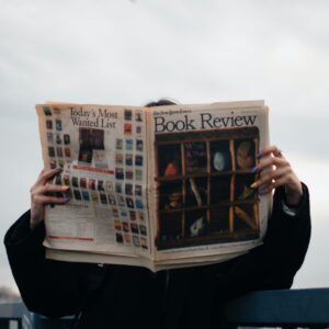 person holding white and brown newspaper