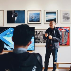man beside flat screen television with photos background