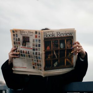 personne lisant un journal promouvoir ses livres avec les relations presse